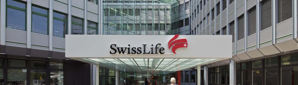 The glass entrance of a Swiss Life Asset Managers office building, under a canopy bearing the company's name and sail mark.